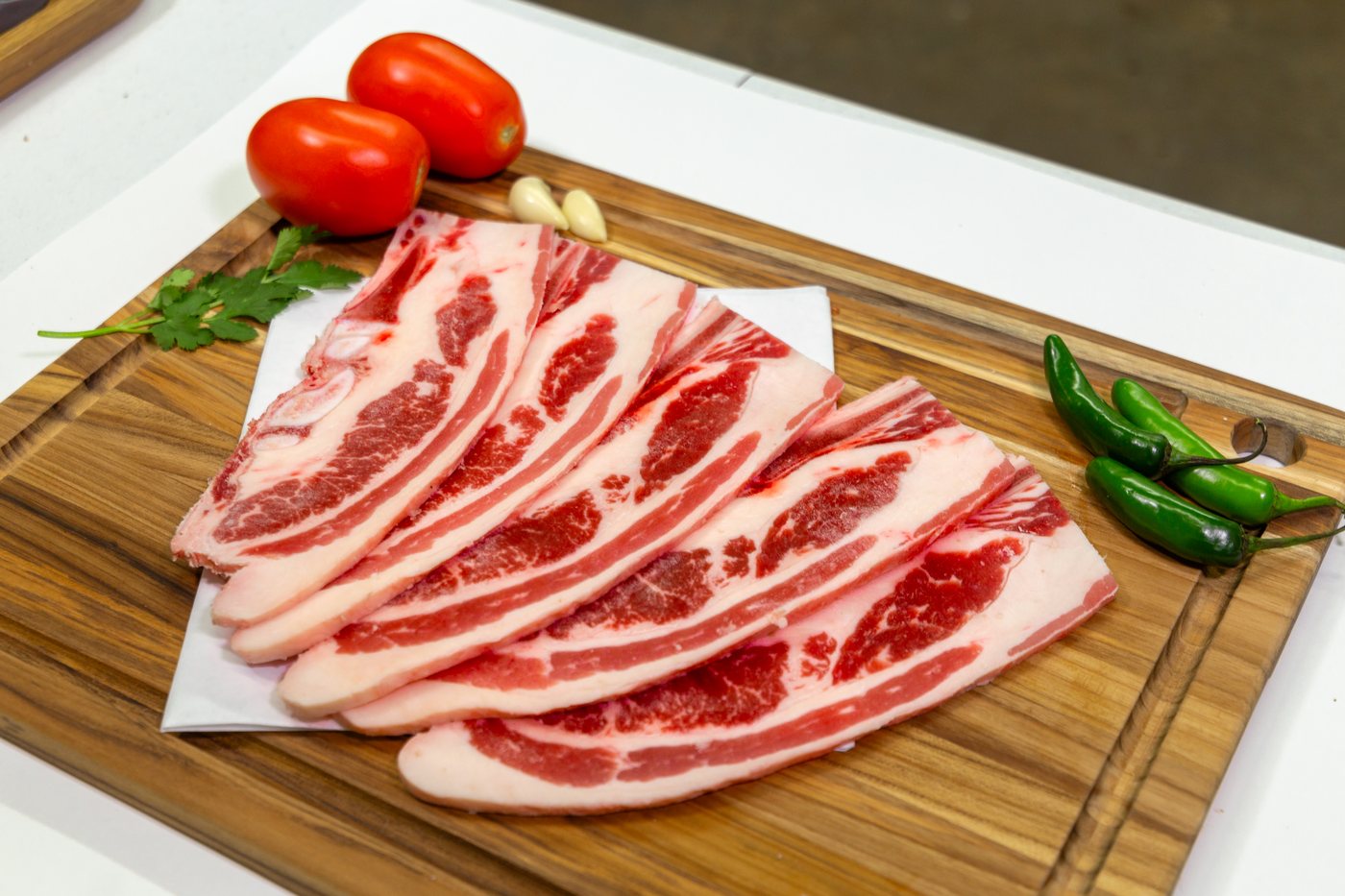 Fresh-cut marbled beef at the Korner Market Karnicería, with tomatoes, garlic, and serrano peppers
